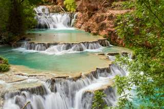 A river flows towards the viewer and falls in a sequence of steps