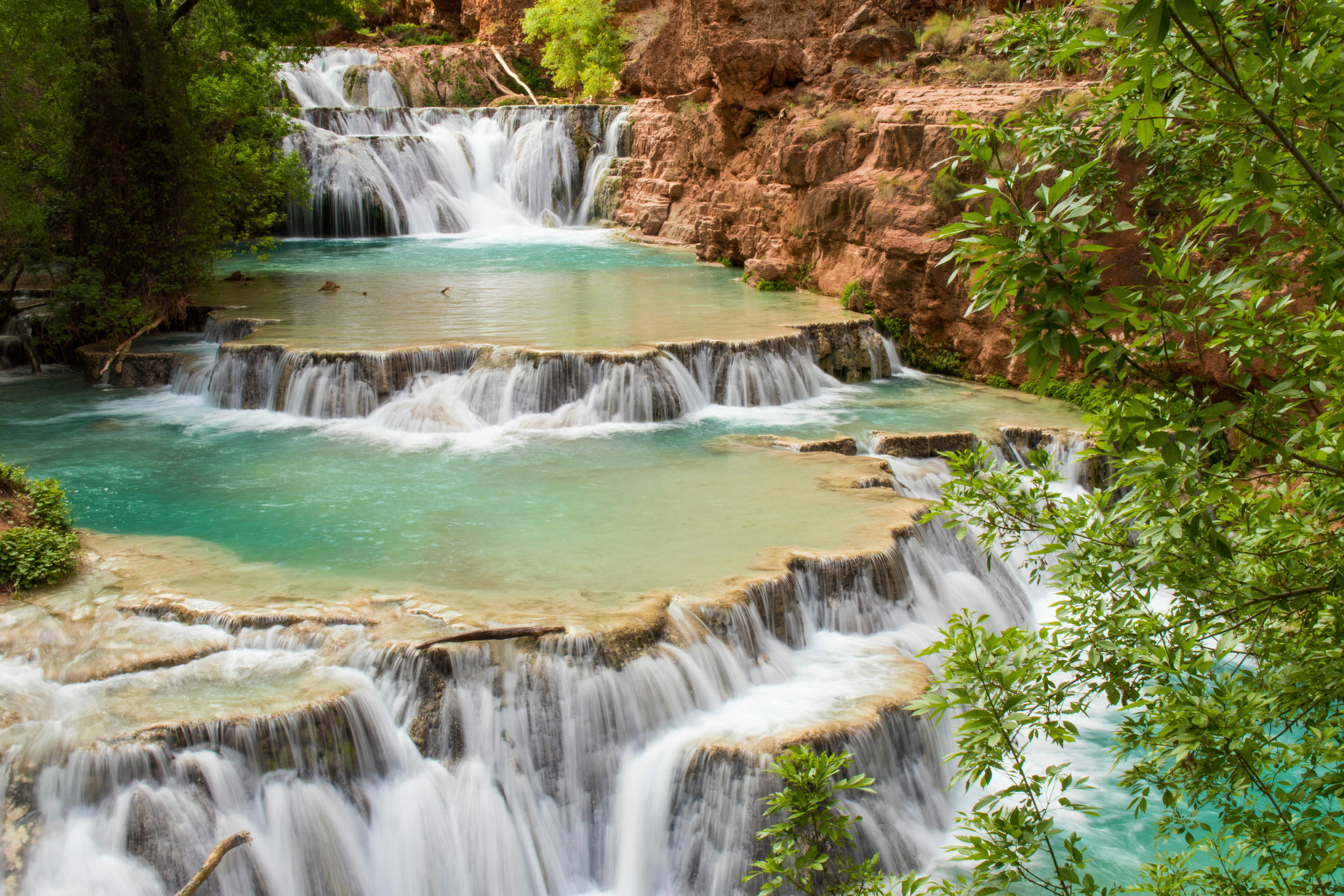 A river flows towards the viewer and falls in a sequence of steps